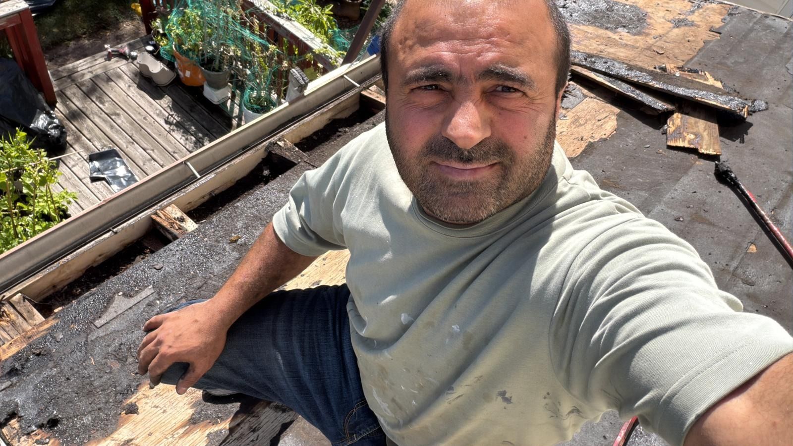 The owner of Bloor Renovation on a roof during a shingle tear-off